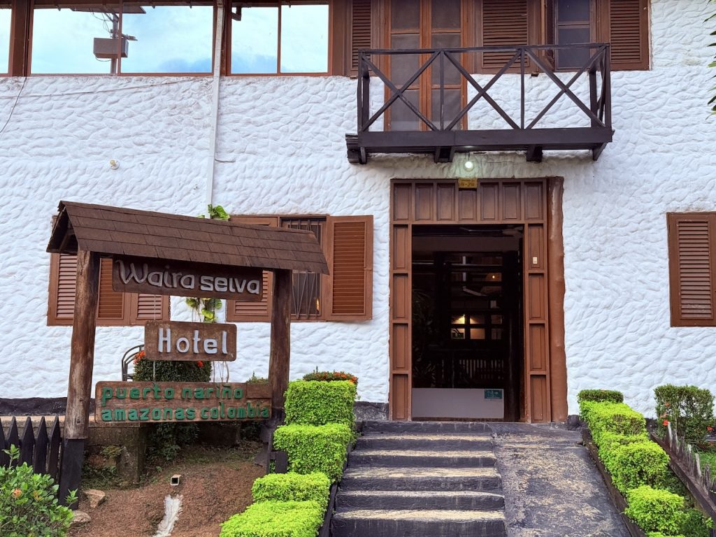 Entrada principal y letrero de madera rústico del Hotel Waira Selva en Puerto Nariño, Colombia.